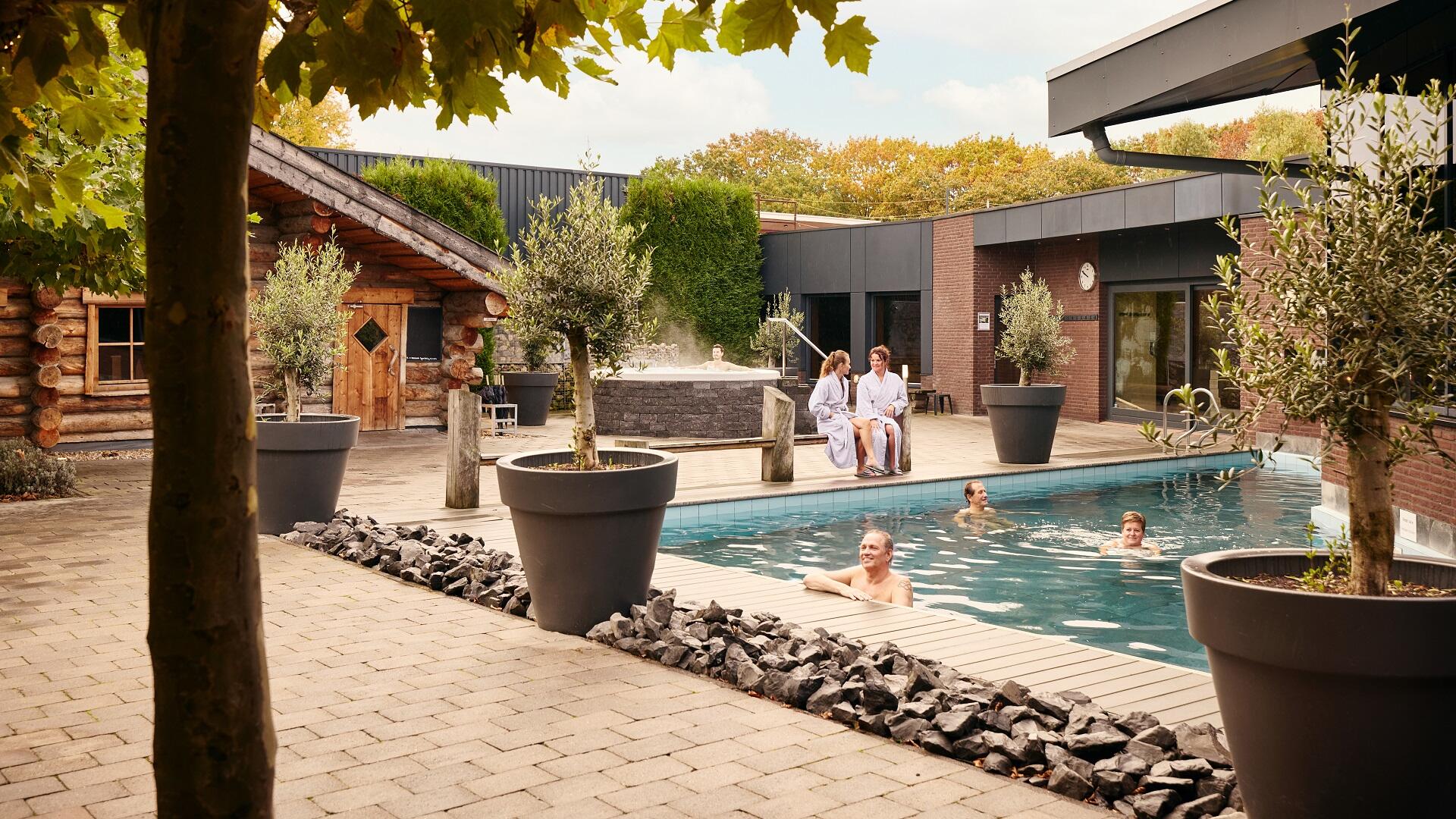 Gasten zwemmen in het buitenbad van SpaPuur